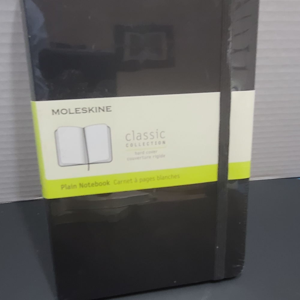 Moleskine plain Medium hardcover notebook.  Black